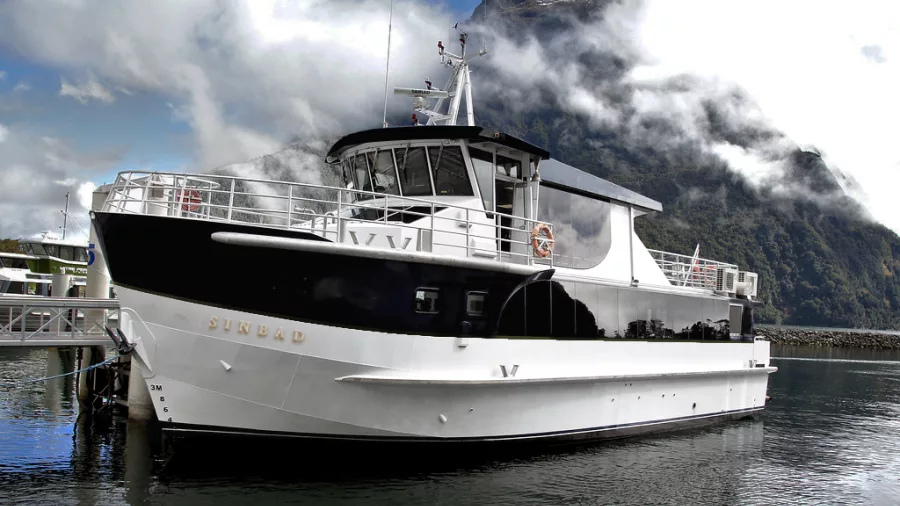 MV Sinbad docked at Milford Sound with misty mountain backdrop