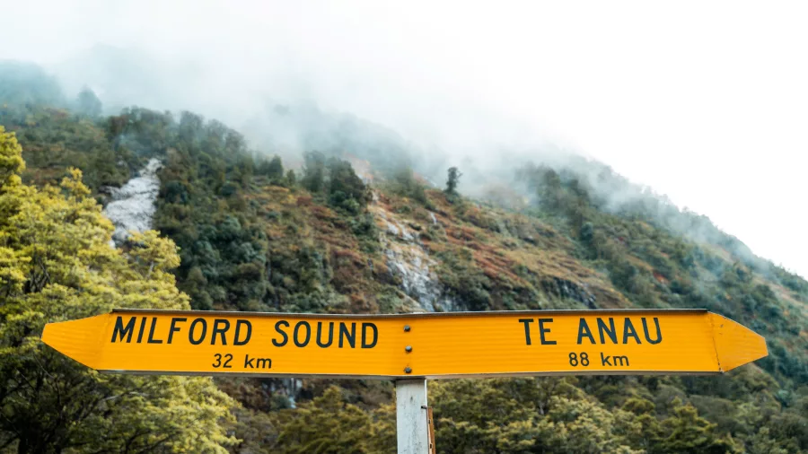 Yellow road sign showing distance to Milford Sound and Te Anau