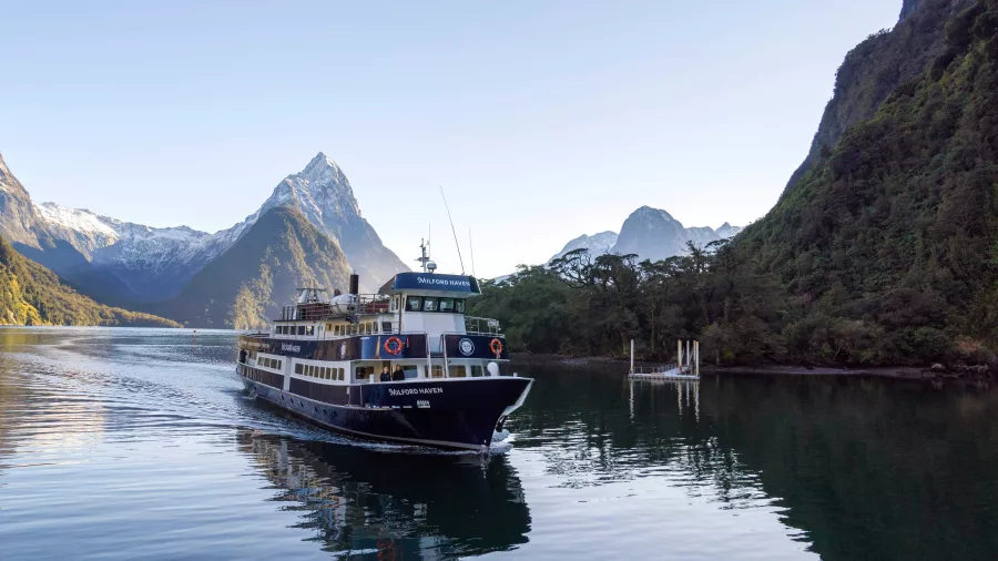 Milford Haven returning to the Milford Sound wharf with Mitre Peak in the background