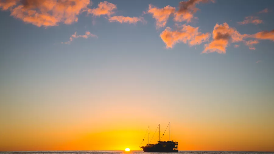 Silhouette of Milford Mariner cruising at sunset in Fiordland