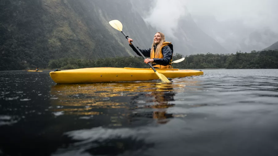 Woman kayaking in Milford Sound during a Milford Mariner overnight cruise