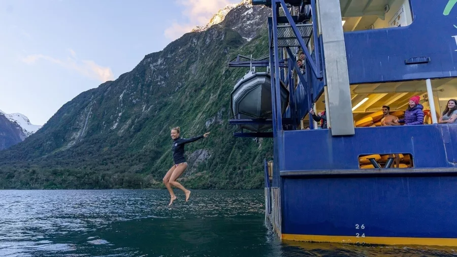 Woman jumps into the waters of Milford Sound from the Milford Mariner