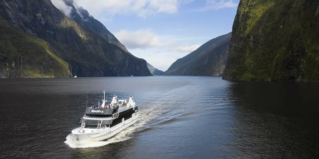 Sovereign boat sailing through the iconic Milford Sound fiord on a daytime cruise