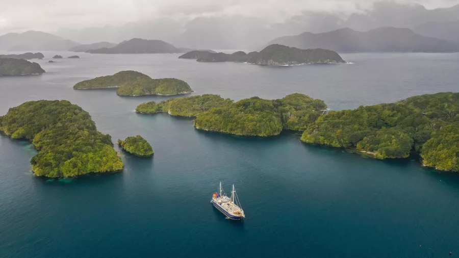 The Milford Wanderer anchored near forest-covered islands in a remote part of Preservation Inlet