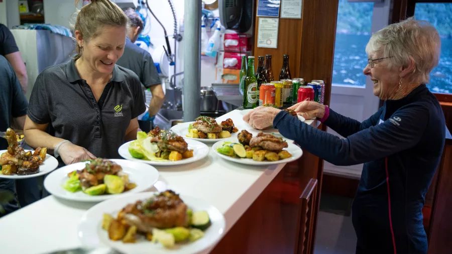 Smiling staff and guests enjoying hearty meals served in the Milford Wanderer’s dining area