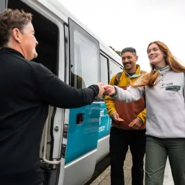 Guests boarding a bus with a warm welcome at the Stewart Island Ferry terminal.