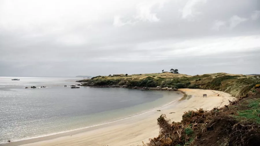 Remote beach at Oneke (The Neck) with walkers and scenic views of Stewart Island’s coastline