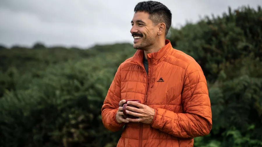 Smiling walker enjoying a hot coffee during a break on the Stewart Island Wilderness Walk