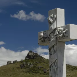 Detailed marble cross in a remote Otago cemetery with rocky hills in the background
