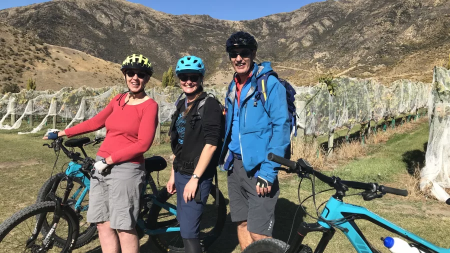 Group posing with e-bikes at vineyard in Queenstown wine country