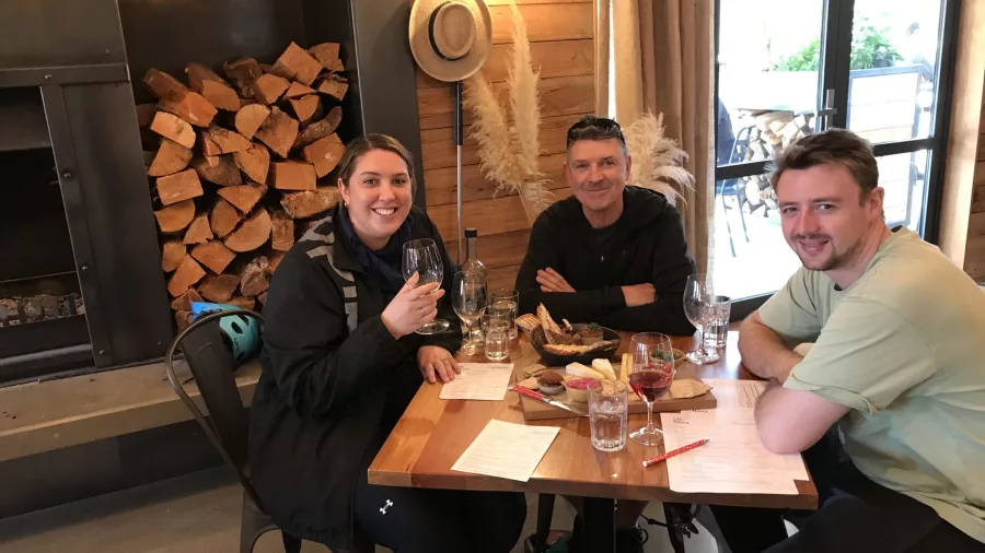 Three people enjoying wine tasting indoors at Gibbston winery