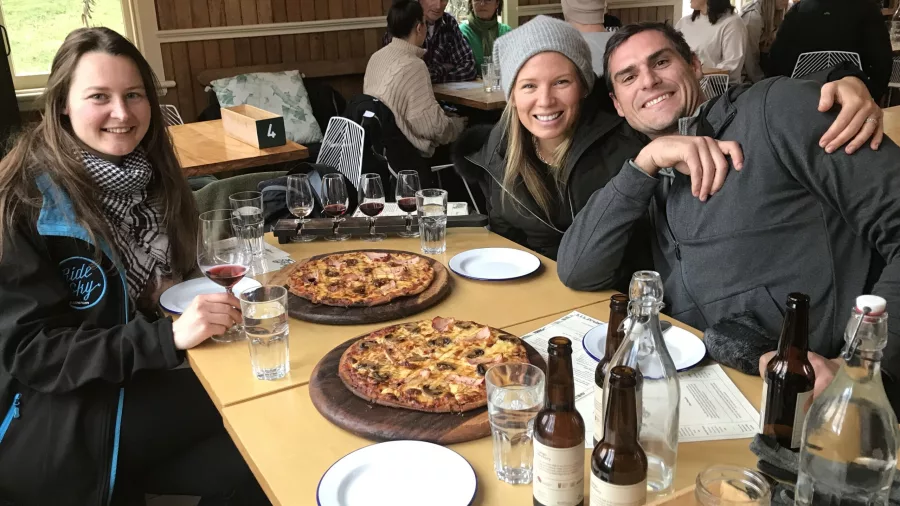 Friends enjoying woodfired pizza and wine tasting at Gibbston Valley winery