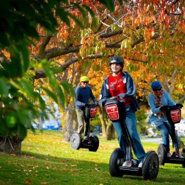 Group riding Segways under autumn trees in Queenstown