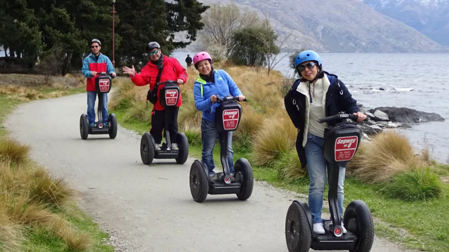 Group of four adults riding Segways along the Lake Whakatipu trail in Queenstown