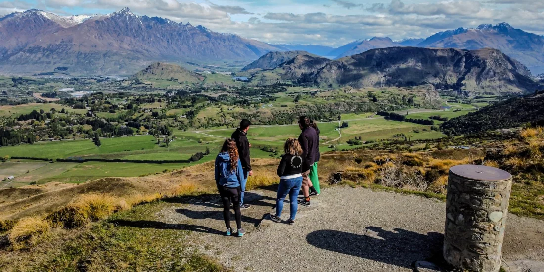 Guided Middle Earth tour group overlooking stunning alpine views near Queenstown