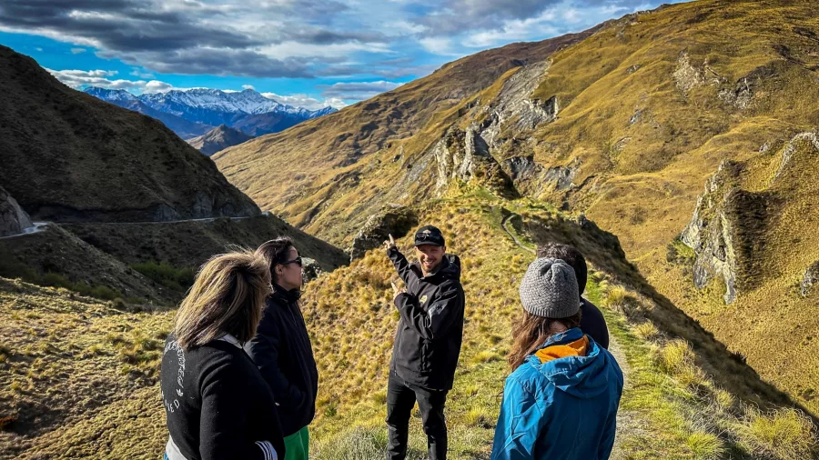 Guide sharing behind-the-scenes stories at a dramatic canyon location from LOTR