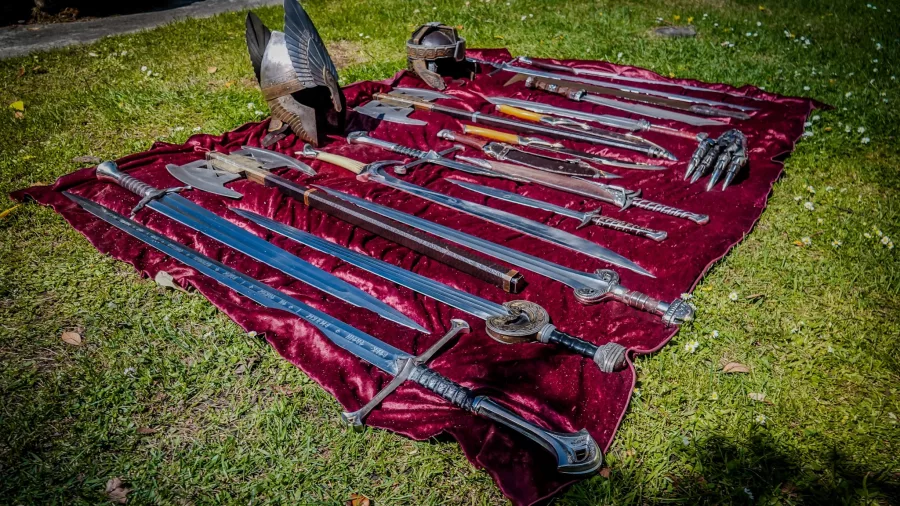 Collection of replica swords and helmets on a velvet cloth from Lord of the Rings tours
