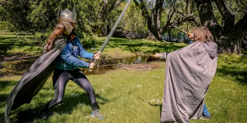 Guests acting out a sword fight in costume during a LOTR location tour