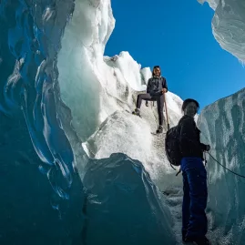 Adventurers exploring an icy crevasse during a guided hike on Franz Josef Glacier