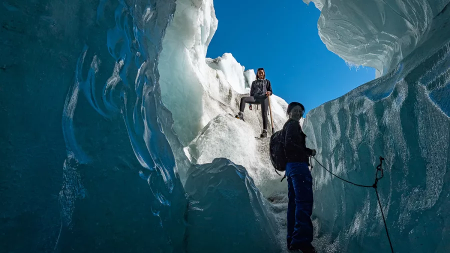Adventurers exploring an icy crevasse during a guided hike on Franz Josef Glacier