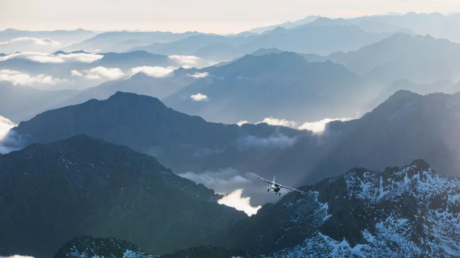 True South aircraft flying above the rugged mountain peaks of Fiordland National Park
