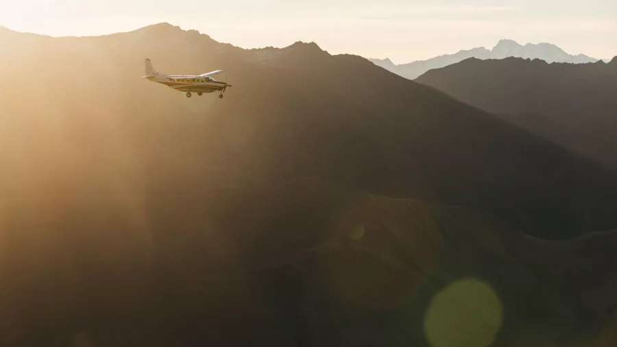 True South plane flying at sunset over remote Southern Alps mountain ranges
