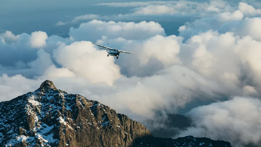 True South scenic flight plane flying into clouds above a rocky mountain
