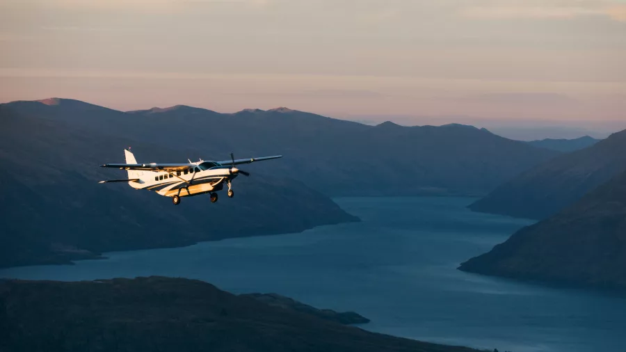 True South aircraft flying above a South Island lake at golden hour