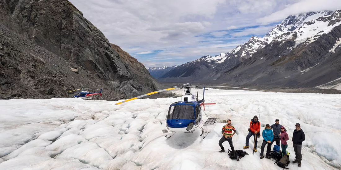 Group standing next to a helicopter on the Tasman Glacier during a helihike tour