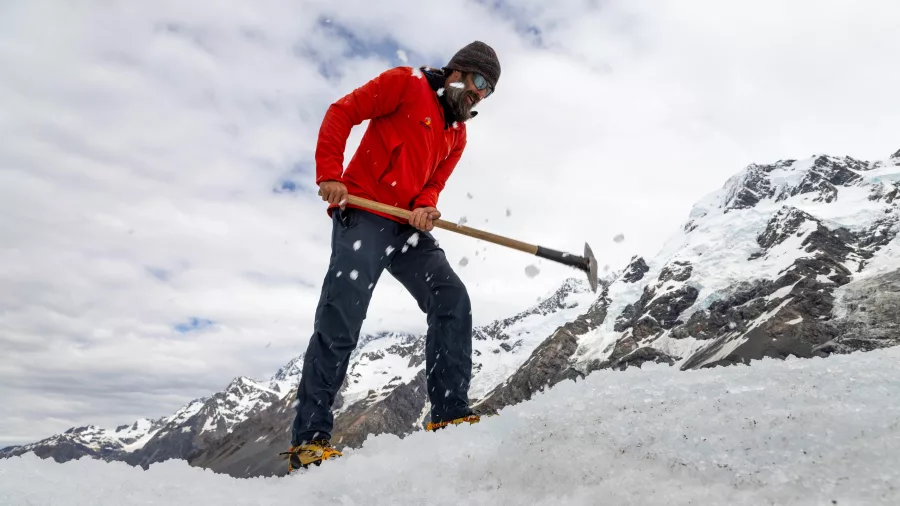 Helihike guide carving safe steps into the ice on the Tasman Glacier