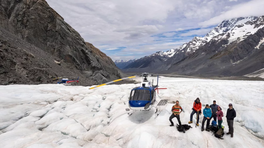 Group standing next to a helicopter on the Tasman Glacier during a helihike tour