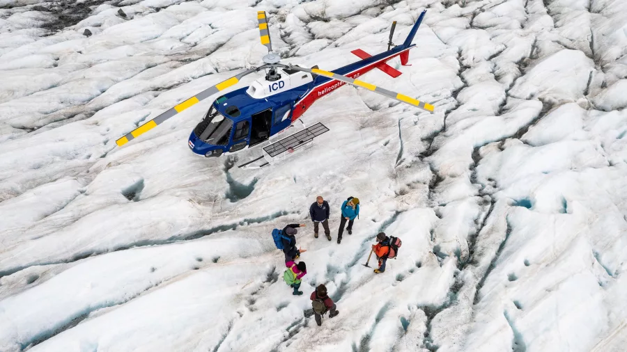 Helicopter and guided hikers on a crevassed section of the Tasman Glacier