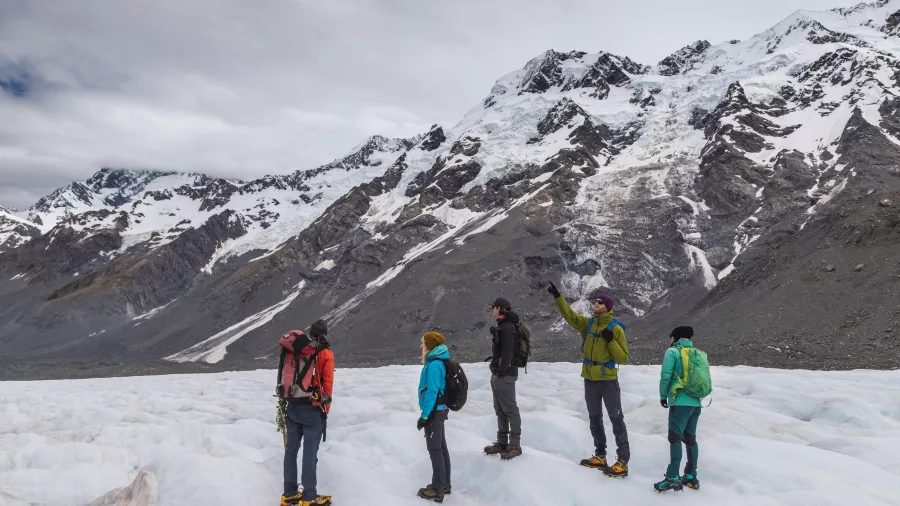 Guide interpreting glacial features for hikers on the Tasman Glacier