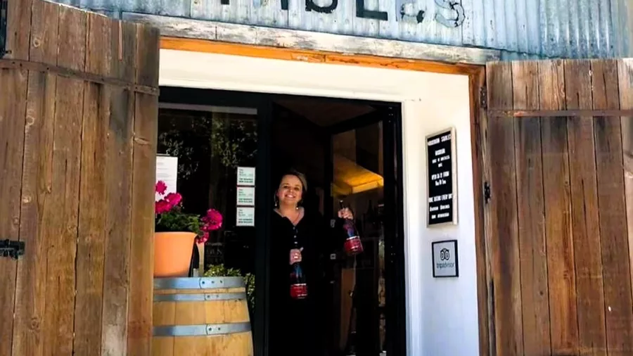 Entrance to Rockburn Stables cellar door in Gibbston with rustic doors and wine barrels