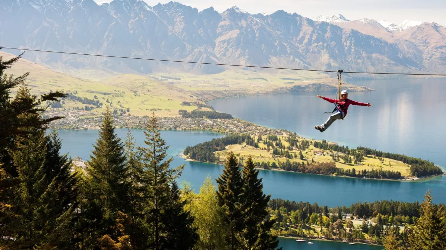 Person ziplining high above Queenstown with views over Lake Whakatipu and The Remarkable