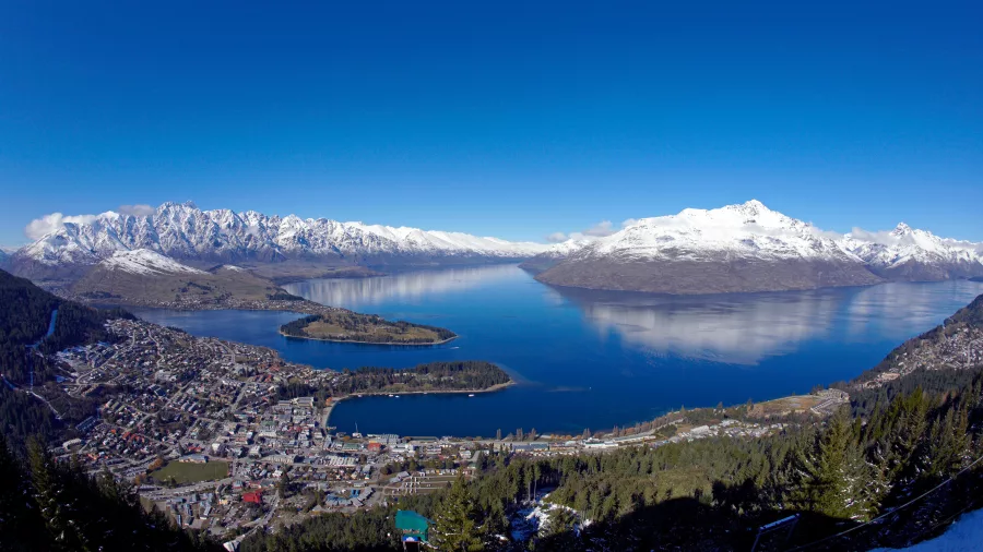 Aerial view over Queenstown with Lake Wakatipu and surrounding snow-covered peaks
