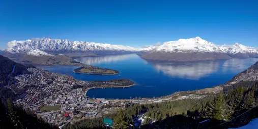 Aerial view over Queenstown with Lake Wakatipu and surrounding snow-covered peaks