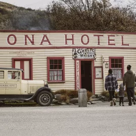 A family walks toward the historic Cardrona Hotel in Wanaka