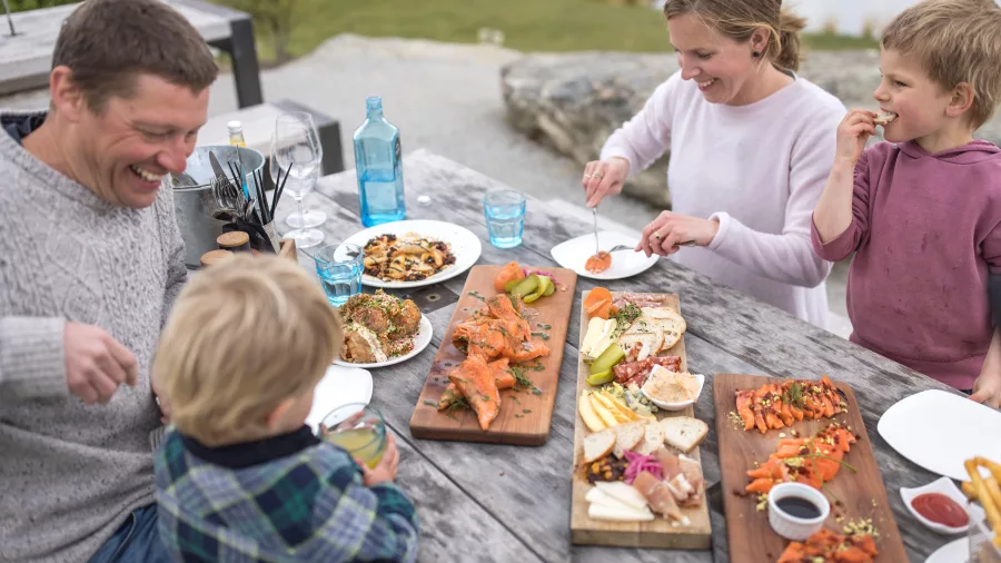 Family enjoying an outdoor meal with shared platters in Wānaka, Otago