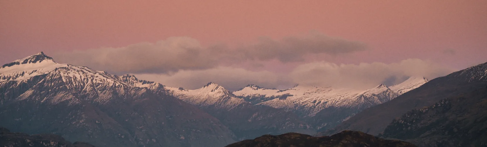 Snow-covered mountains of Aspiring National Park at sunset seen from Lake Wānaka