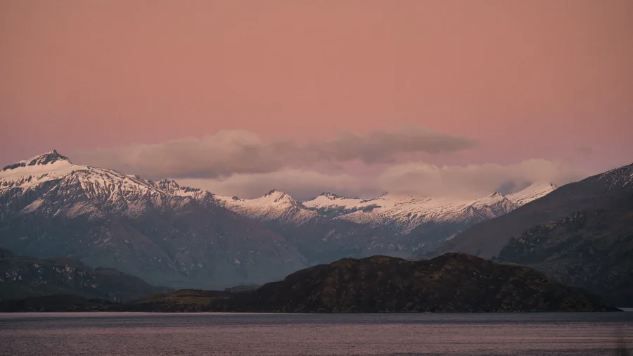 Snow-covered mountains of Aspiring National Park at sunset seen from Lake Wānaka