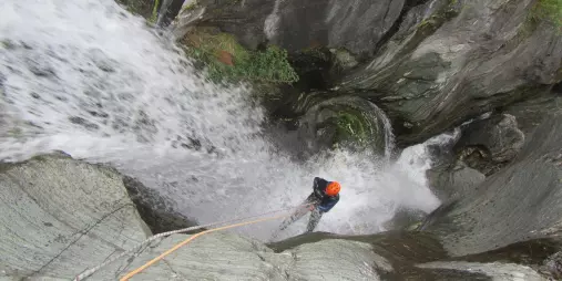Canyoner abseiling down a steep waterfall in Big Nige Canyon near Wānaka.