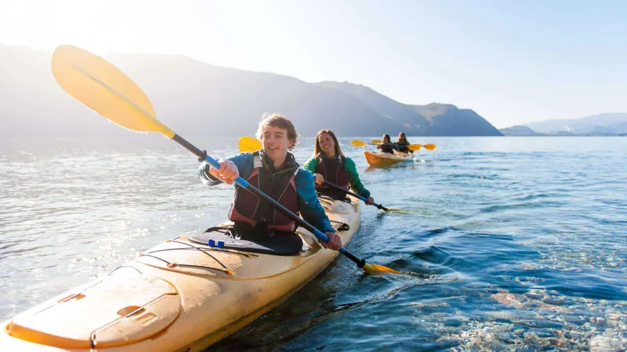 Happy kayakers paddling on Lake Wānaka during a Tiki Guided Kayak Tour