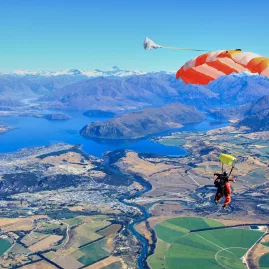 Tandem parachute open with aerial view of Lake Wanaka and surrounding countryside