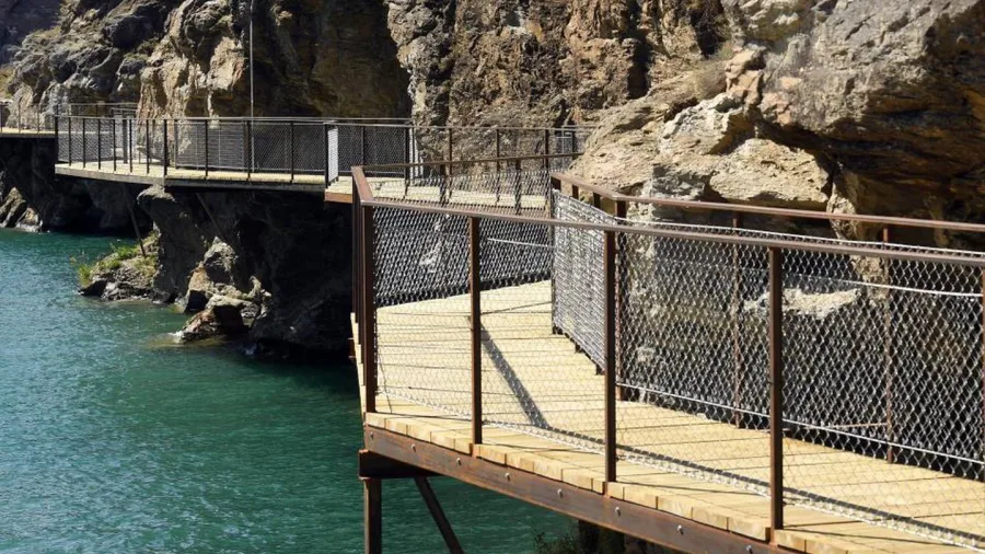 Cantilevered boardwalk built into cliffside above Lake Dunstan