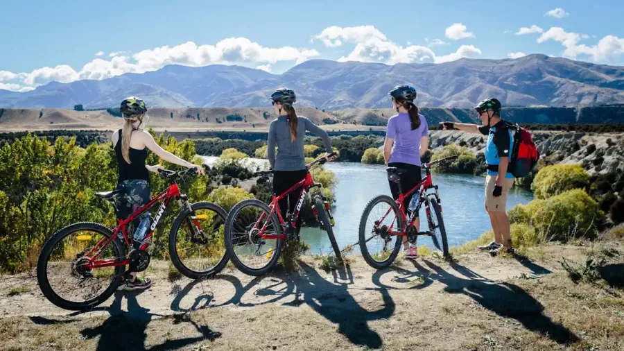 Cyclists enjoying a scenic lookout over the Upper Clutha River on the Albert Town to Wanaka bike trail.