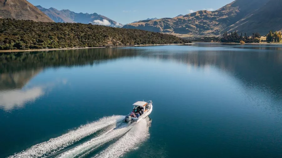 Boat crossing calm waters of Lake Wānaka