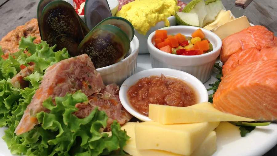 Locally sourced gourmet platter featuring salmon, mussels, cheese, chutney, and fresh produce at Carrick Vineyard.