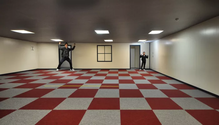 Ames Illusion Room at Puzzling World in Wānaka showing a visual size distortion between two people