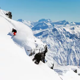 Snowboarder riding down steep terrain at Cardrona Alpine Resort, Wanaka